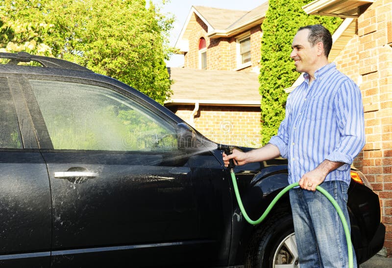 Person doing simple home maintenance like washing their car in the driveway, representing the minimal upkeep needed for electric vehicles compared to gas cars
