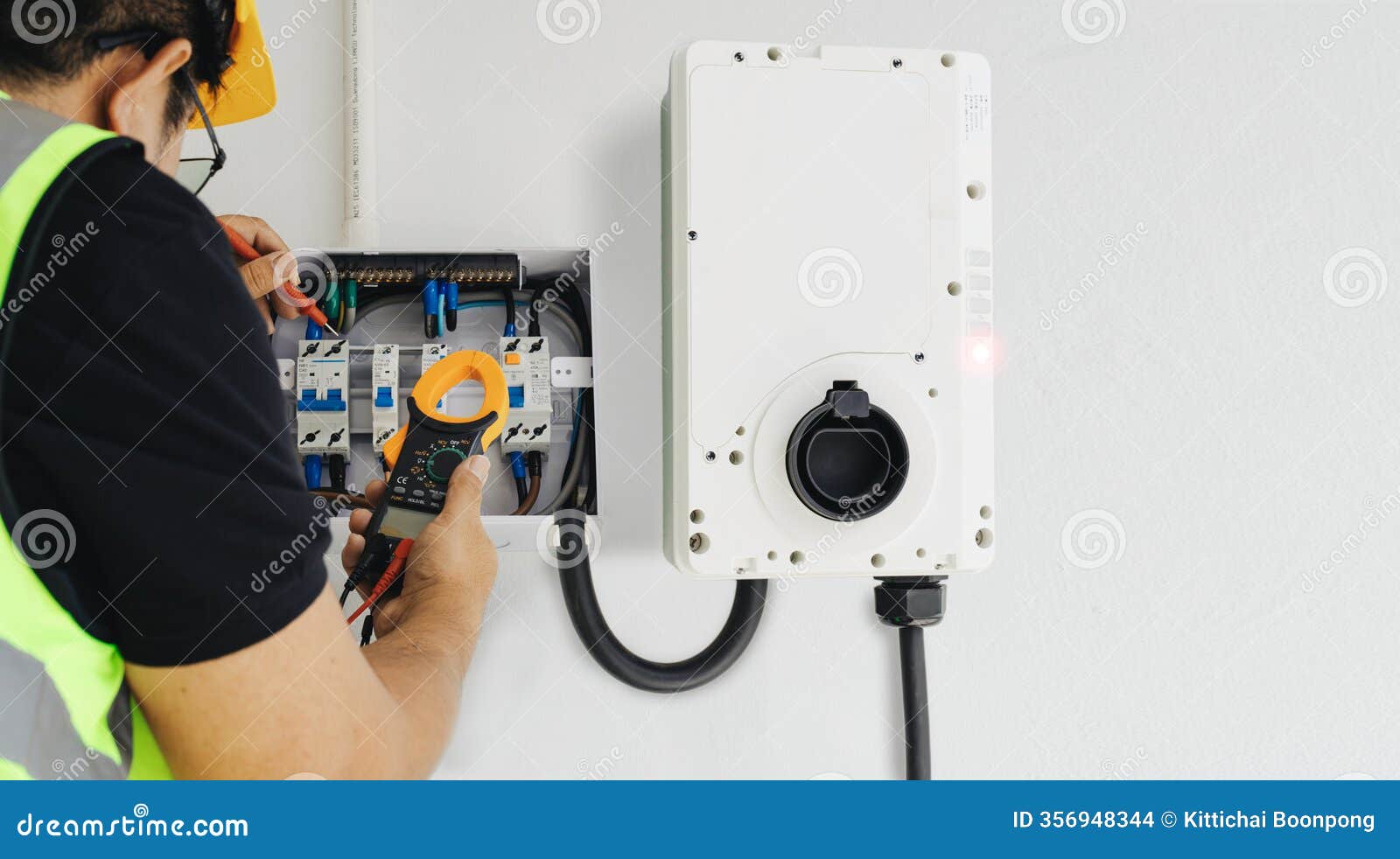 Professional electrician using tools to test and install a home EV charger safely, showing the expertise needed for proper electrical work and code compliance
