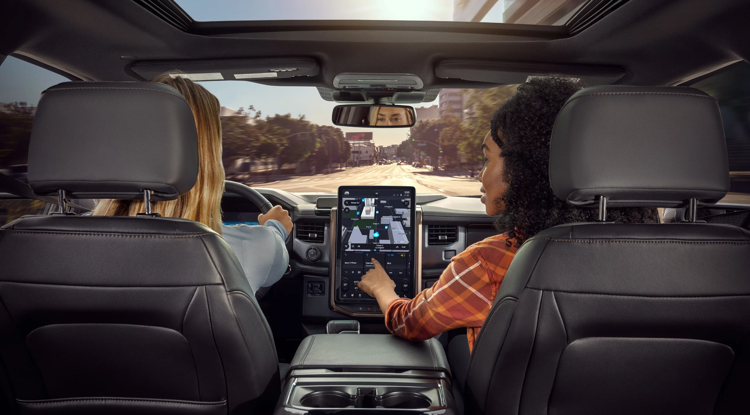 Spacious interior of the Ford F-150 Lightning with passengers using the large touchscreen, showing family-friendly comfort in an electric pickup truck