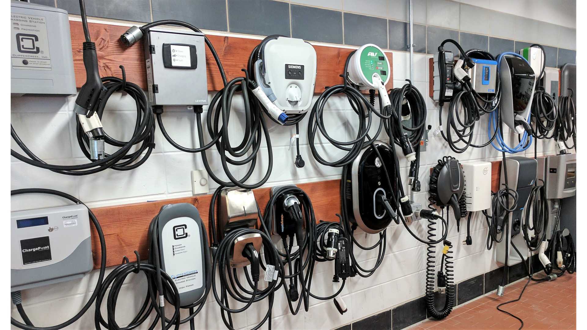 Wall display of multiple Level 2 home EV chargers with cables hanging, perfect for comparing options for speed and reliability when choosing the best for your garage in 2026