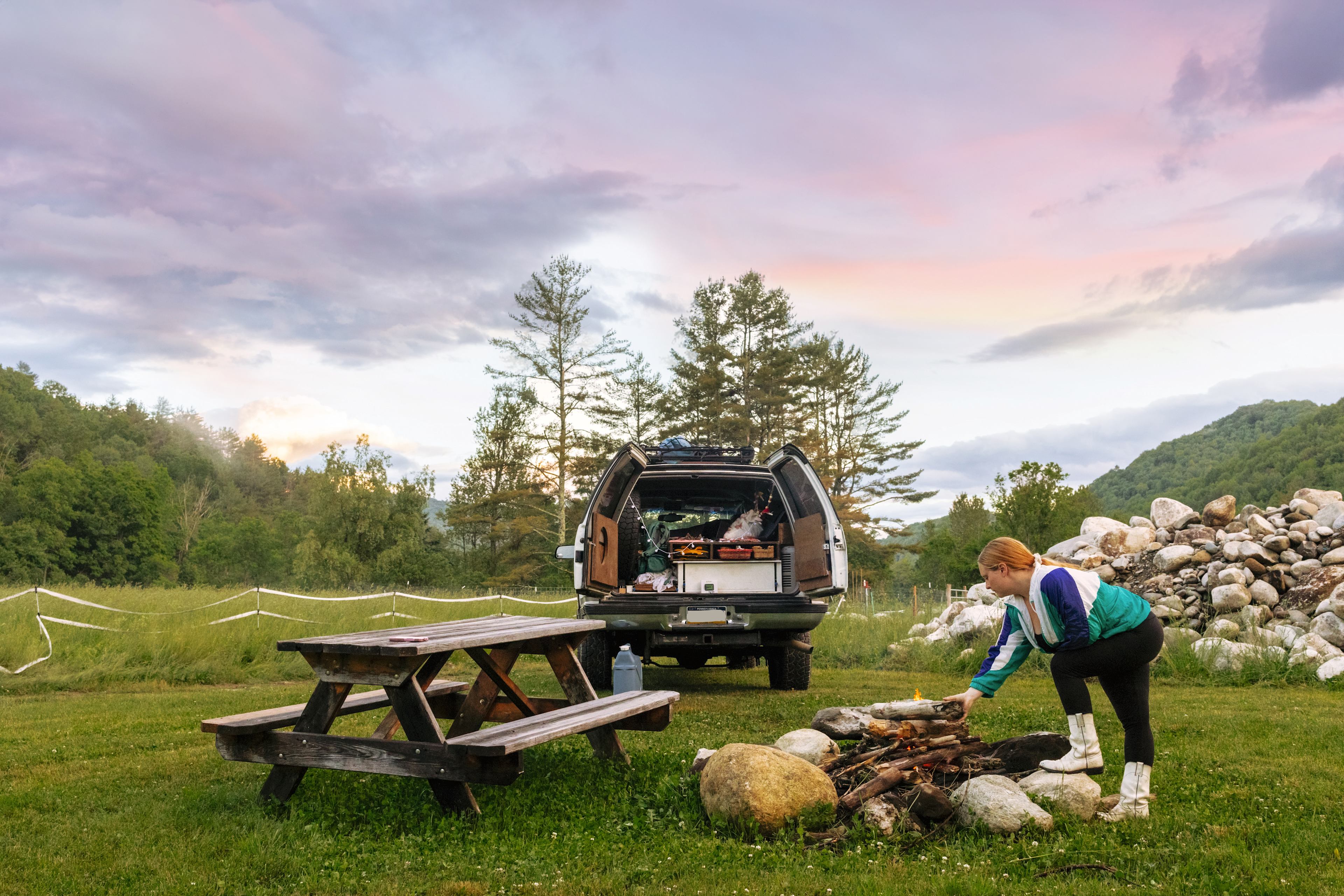 Family enjoying a peaceful outdoor evening near their parked electric SUV in a scenic spot, showing the adventure potential of long-range EVs under $40,000 for US families.