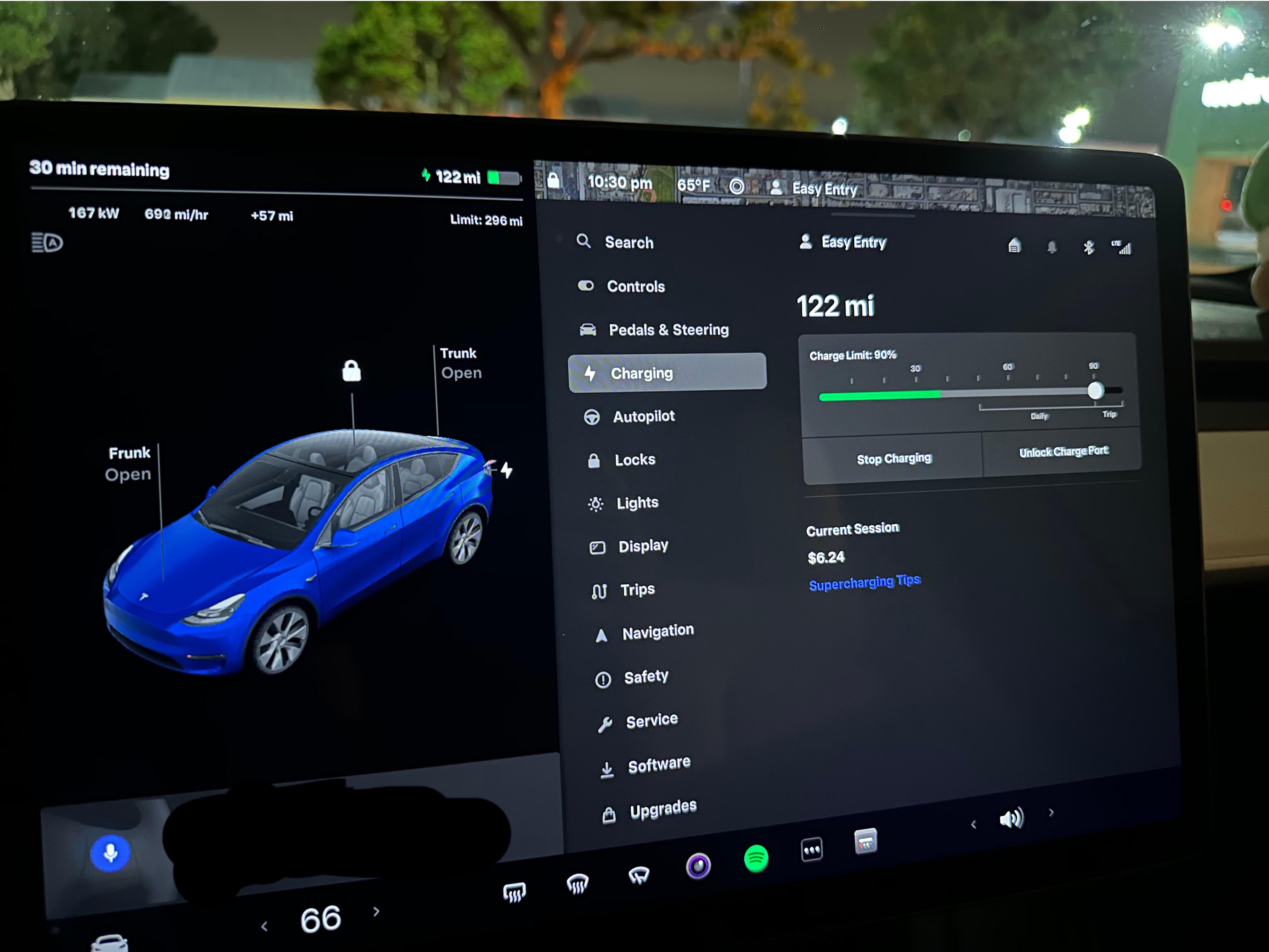 Close-up of a Tesla touchscreen displaying charging status, battery percentage, and supercharging details inside the car, showing real-world fast charging in progress