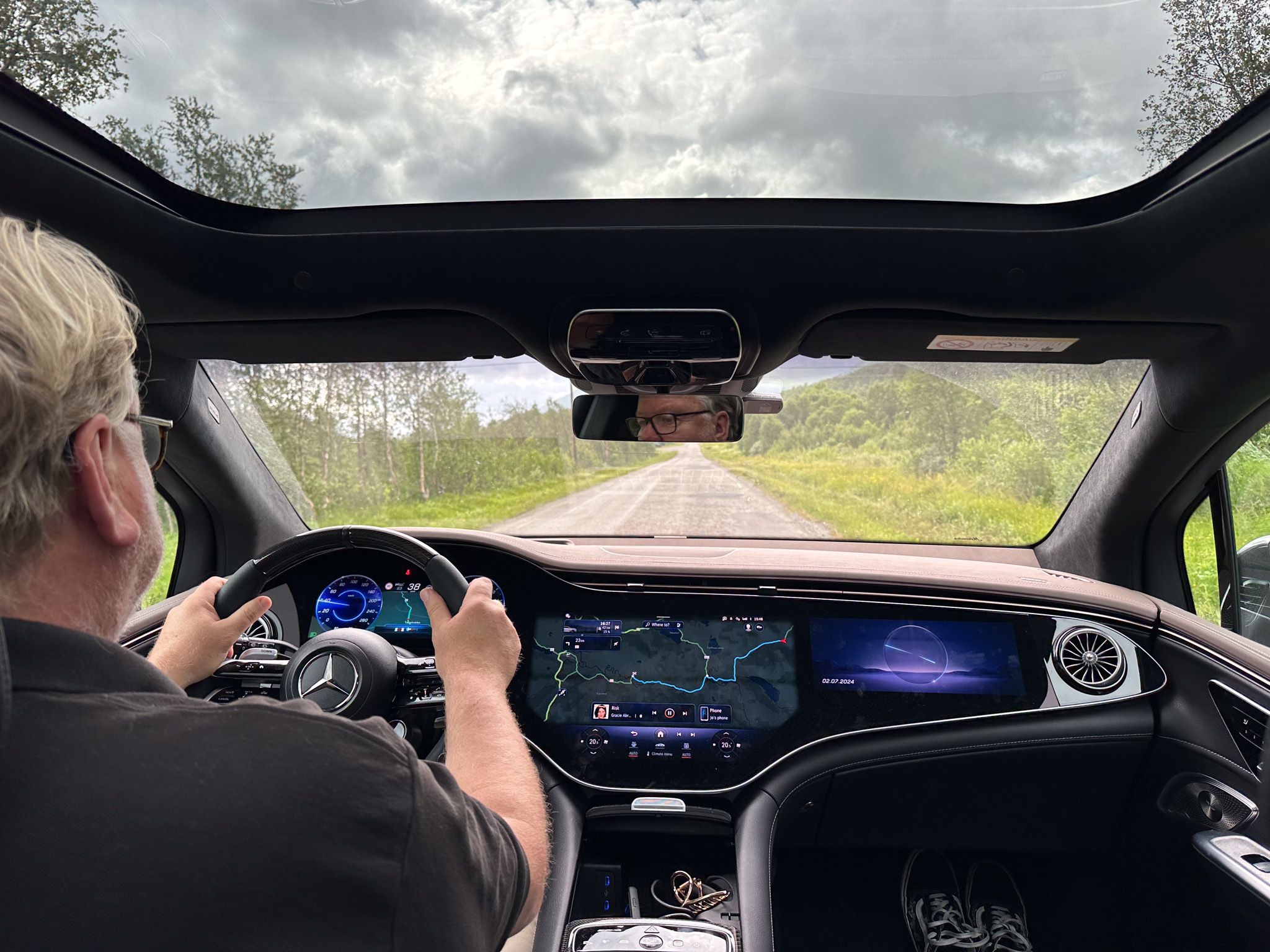 Driver enjoying a scenic mountain road from inside an electric vehicle, capturing the freedom and confidence that comes with having a portable EV charger for road trips