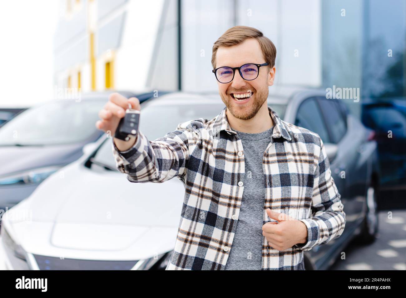 Happy person receiving new car keys at dealership after deciding to buy an electric vehicle instead of leasing in 2026