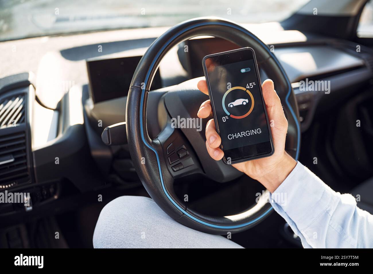 Person using a smartphone app to monitor and schedule electric vehicle charging during off-peak hours, a simple way to save on power bills