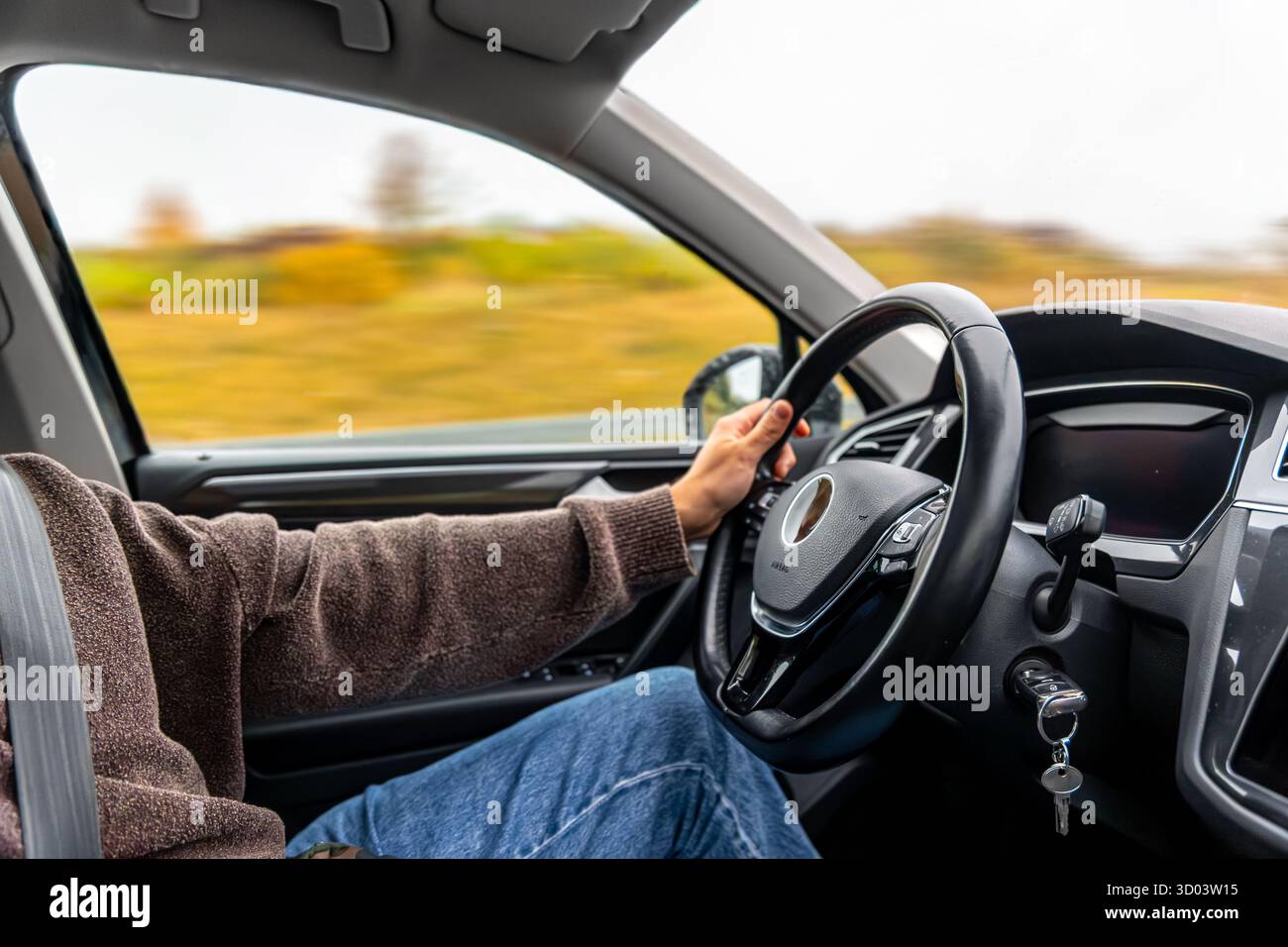 Driver's view from inside an electric car on a calm highway, illustrating smooth driving habits to preserve EV battery longevity