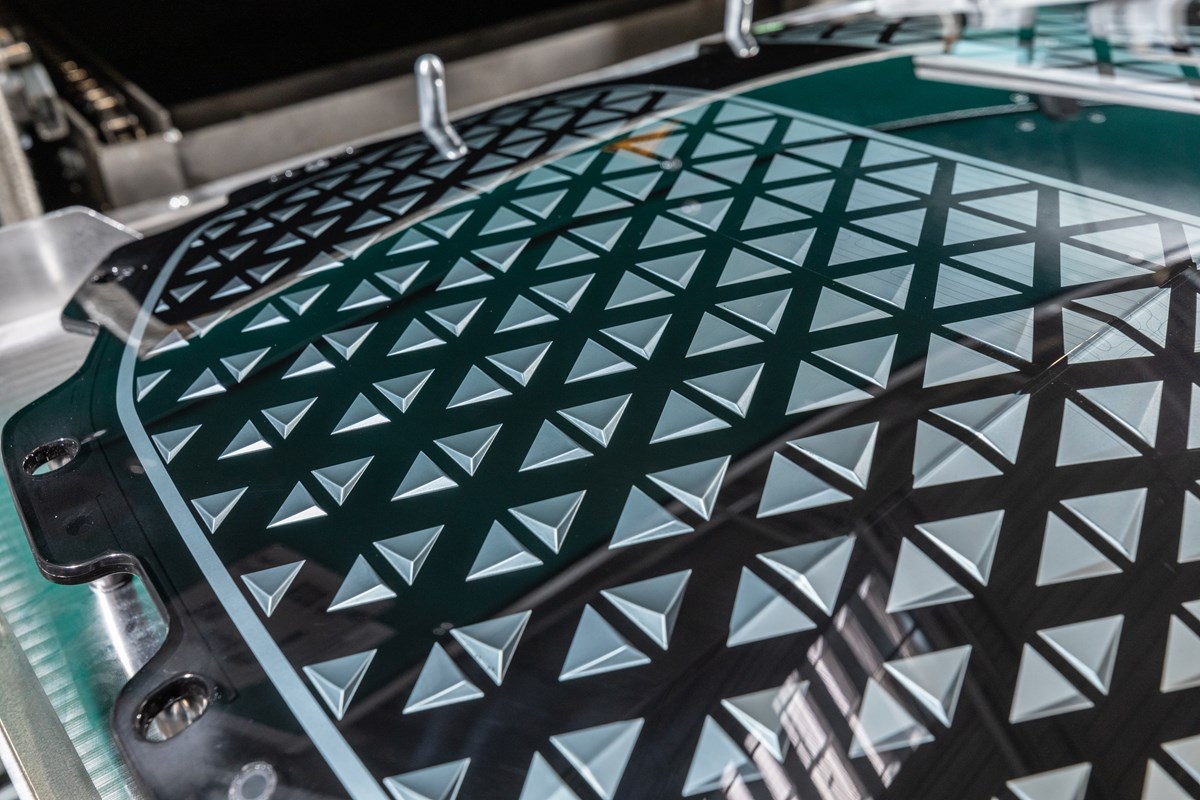 Real front view of a modern electric vehicle grille designed with airflow patterns to support the battery radiator and cooling system in EVs.