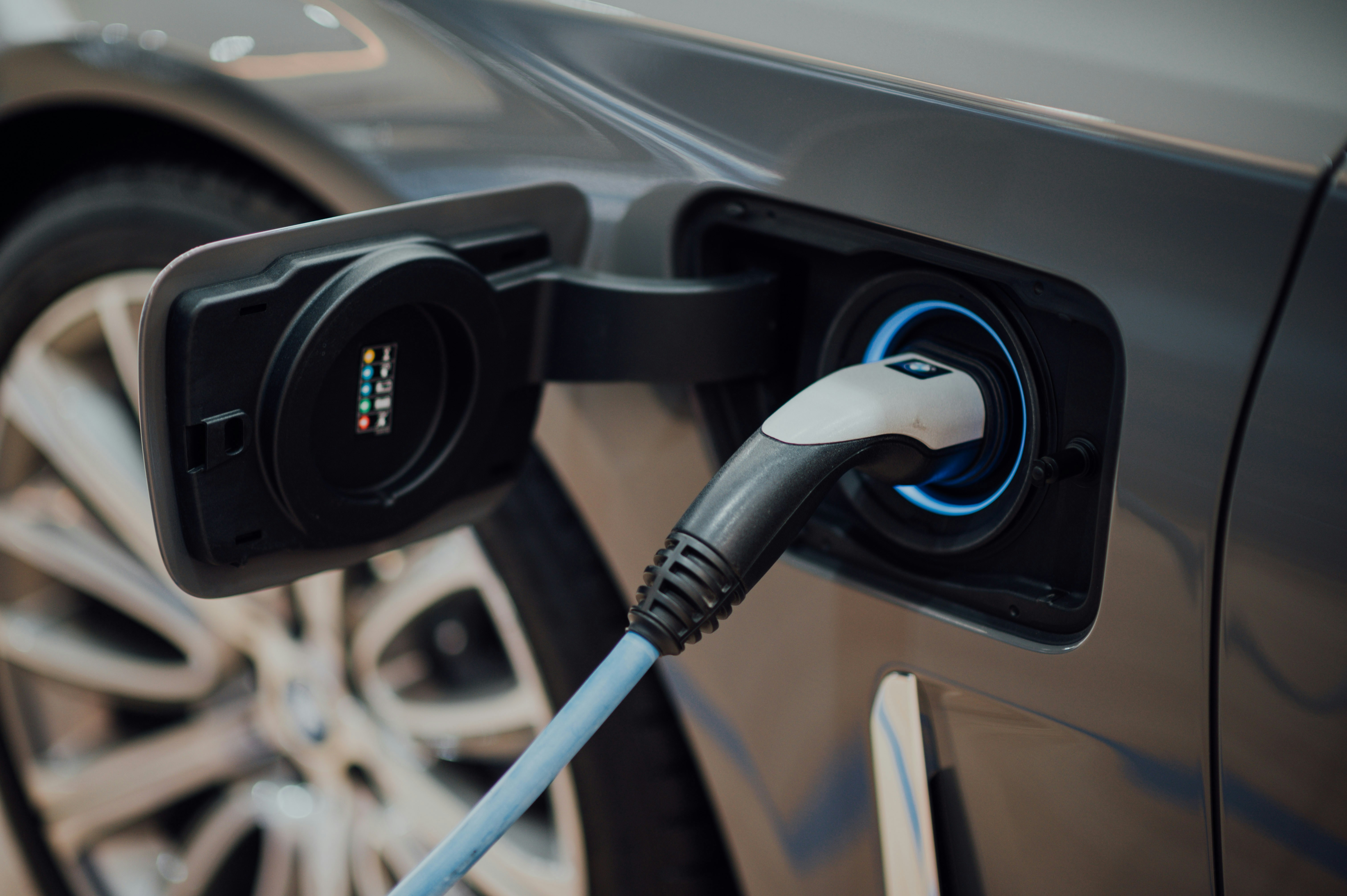 Close-up of a charging cable plugged into an electric vehicle's port in natural light, emphasizing proper use of free EV charging stations