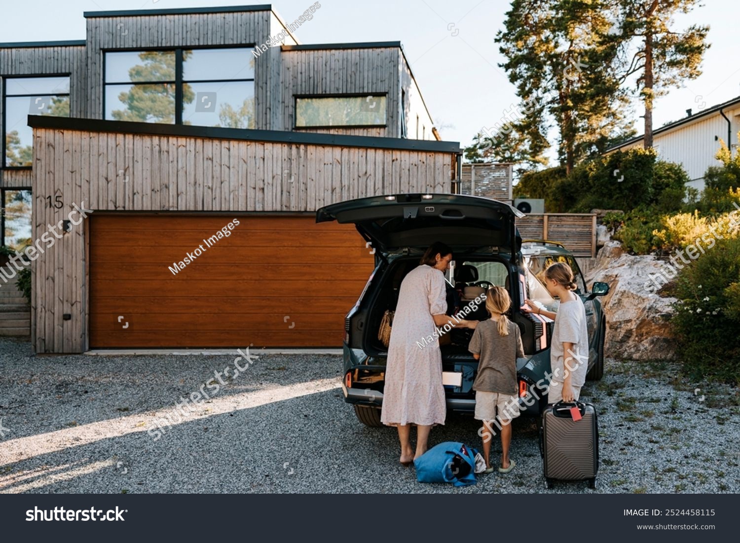Mother and kids packing the trunk of their modern electric SUV at home before a family trip, highlighting practical storage in affordable long-range EVs for US families.