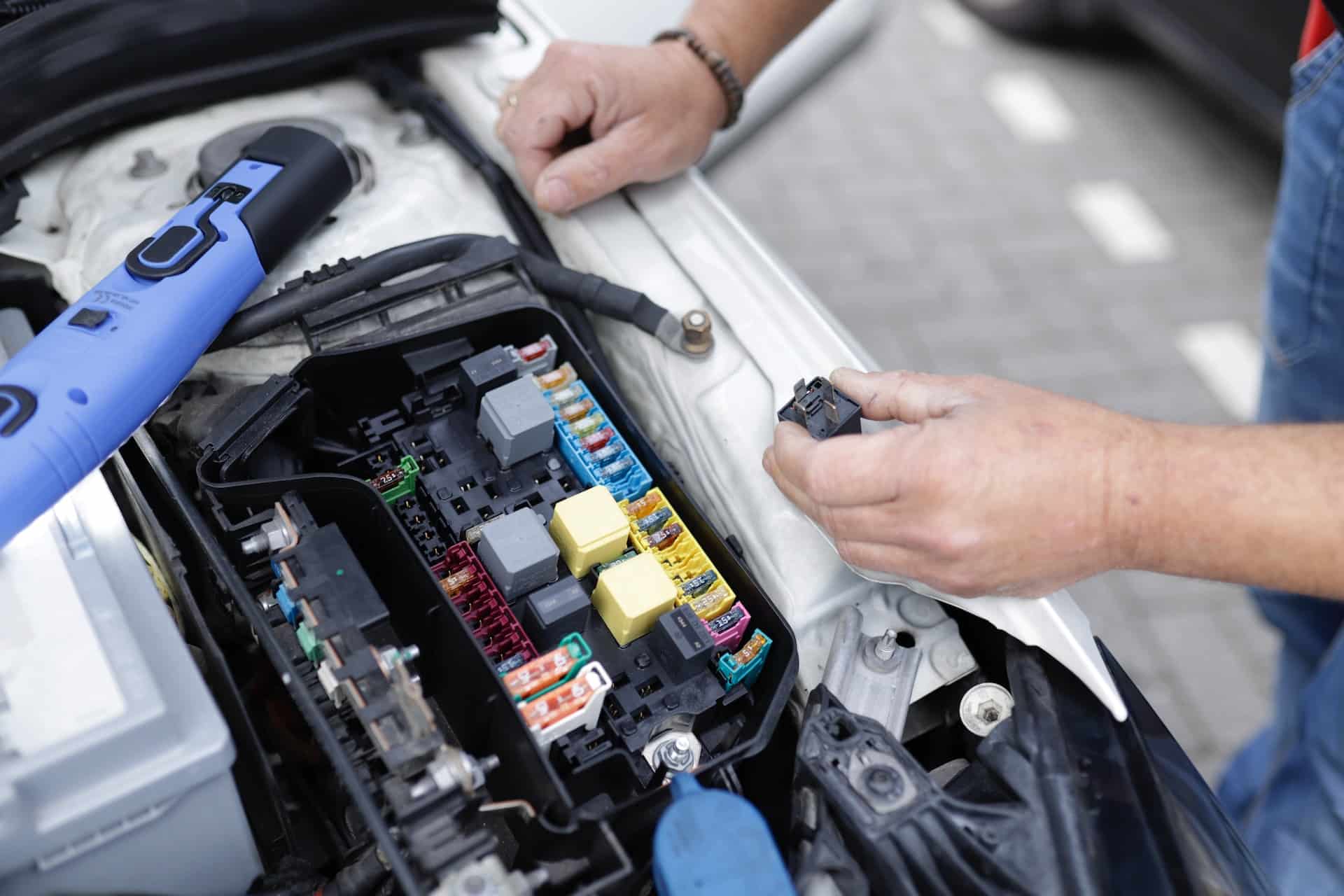 Technician working on an electric vehicle battery system in a workshop, representing the professional inspection needed for thorough battery health checks on used EVs