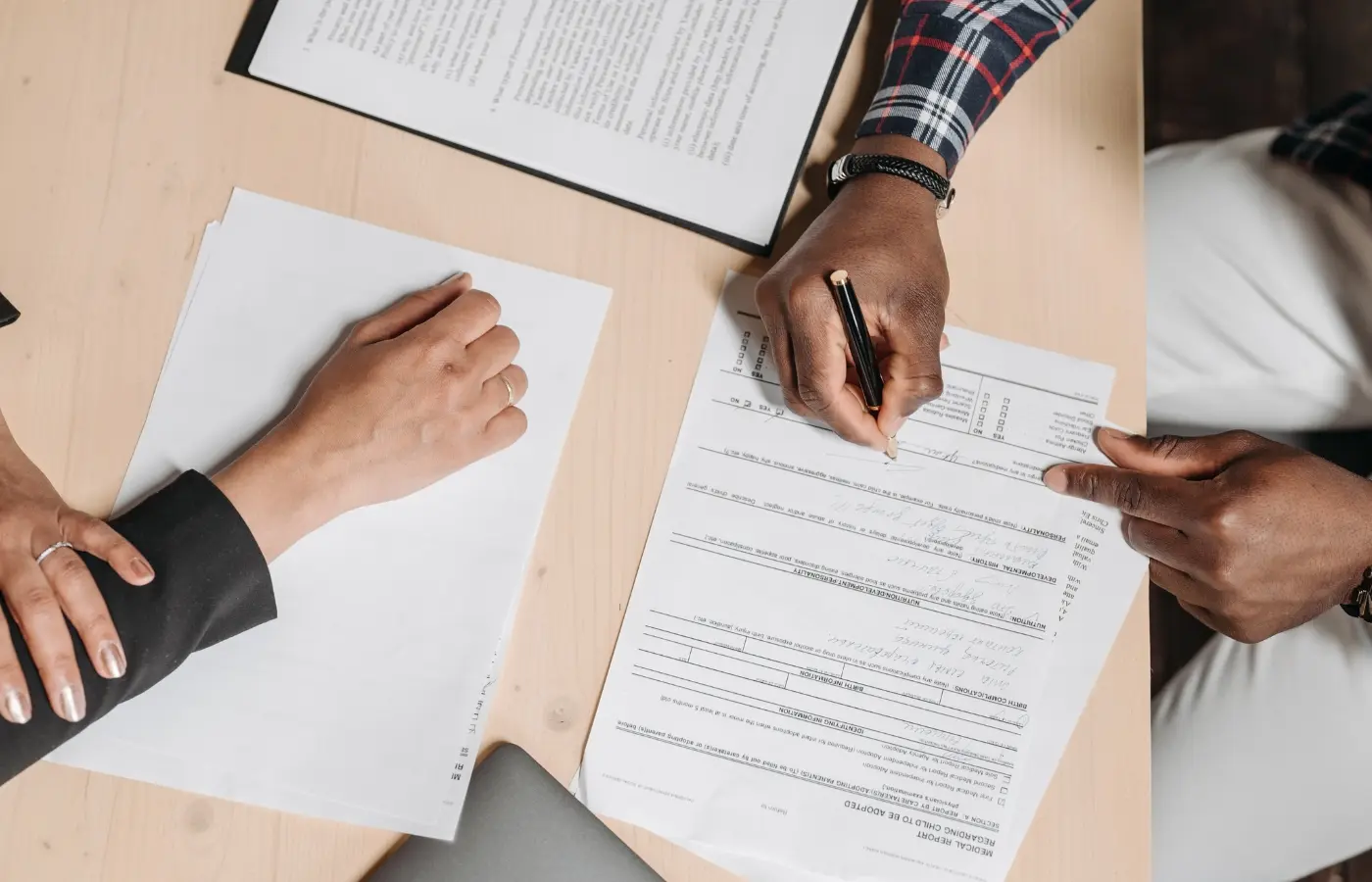 Customer at car dealership signing lease agreement papers for new electric vehicle, comparing EV lease options in 2026