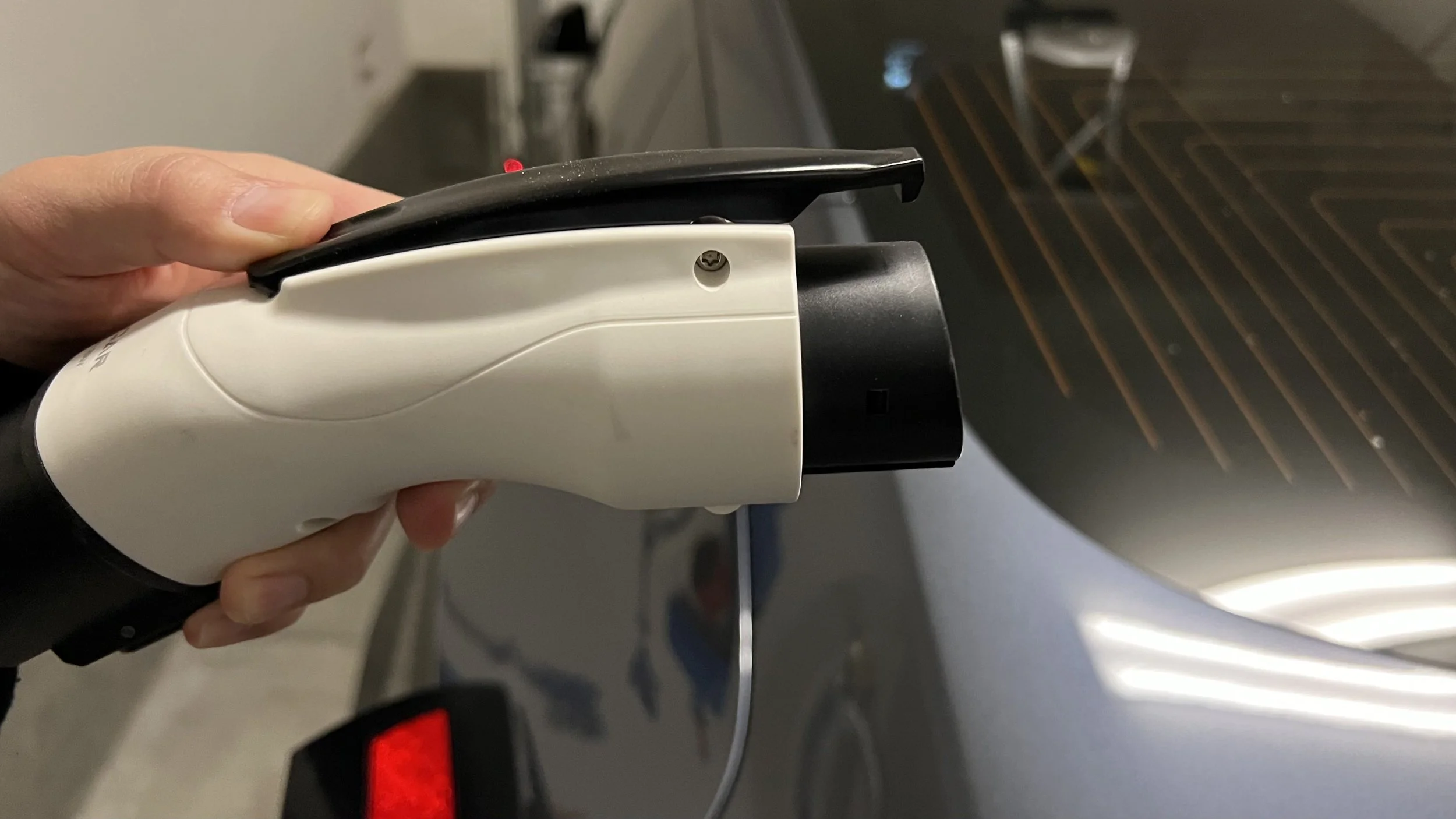 Real close-up photo of a Tesla to J1772 adapter being used to connect different EV charging connectors for compatibility