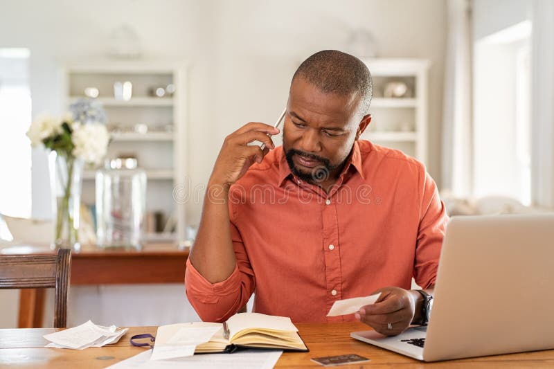 Person reviewing bills and expenses at home, thinking through the real costs of gas vs electric car ownership over thousands of miles