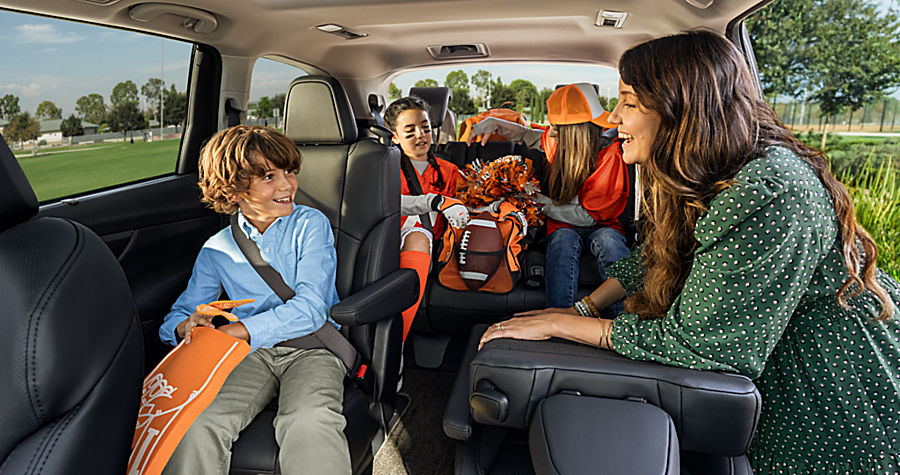 Happy family riding in the roomy back seat of a spacious electric SUV, kids smiling and relaxed, ideal for comfortable trips in long-range EVs under $40,000 for US families.