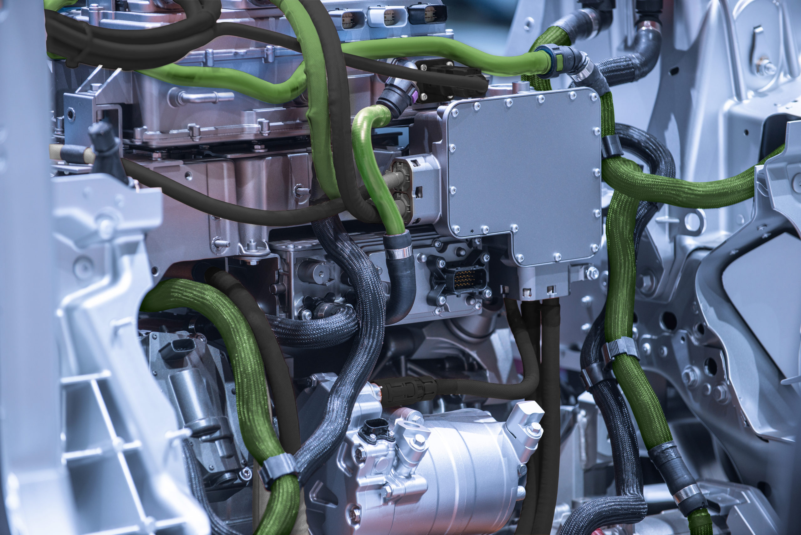 Close-up real photo of green and black liquid cooling pipes weaving through an electric vehicle battery pack, showing the intricate setup for efficient EV battery thermal management.