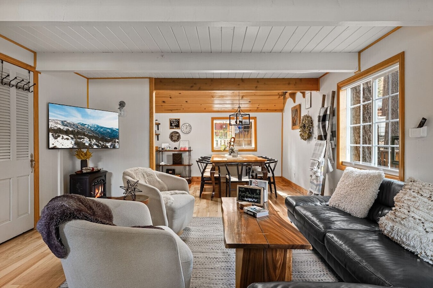 Cozy modern living room in the evening with family relaxing while their EV charges outside, enjoying the benefits and savings of smart off-peak charging