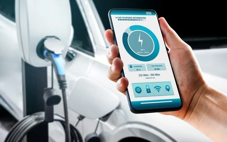 Hand holding a smartphone showing a Level 2 EV charger app with charging progress and controls, making home charging smarter and more convenient