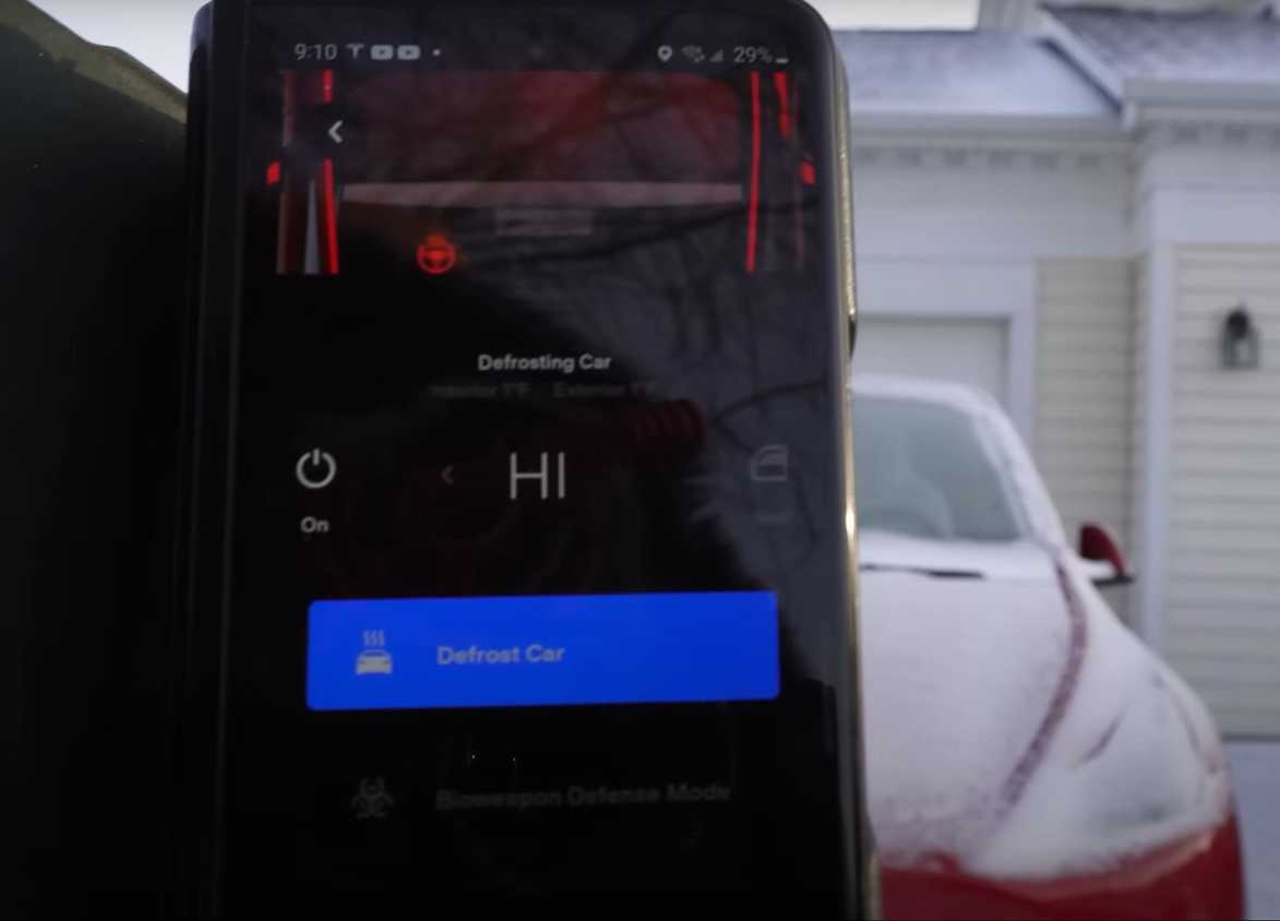 Smartphone displaying EV app with options to defrost and precondition the battery and cabin before driving in cold weather