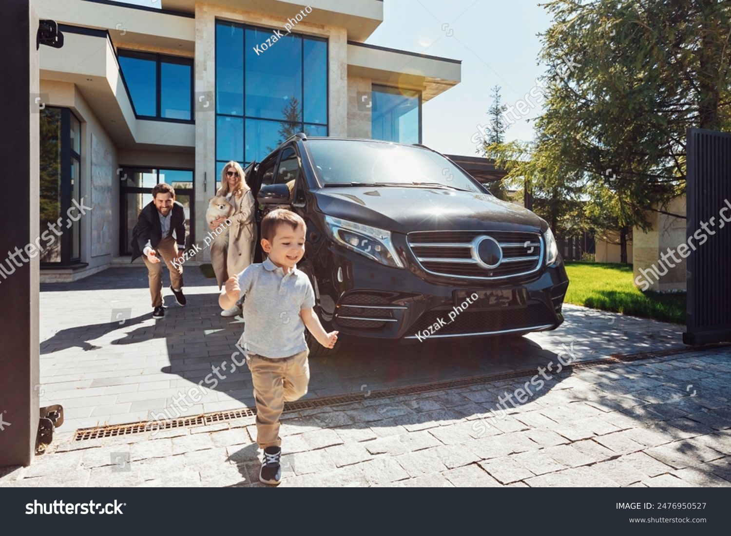 Family home with luxury car parked outside on a sunny day, natural photo representing the savings from bundling home and auto insurance for electric vehicle owners
