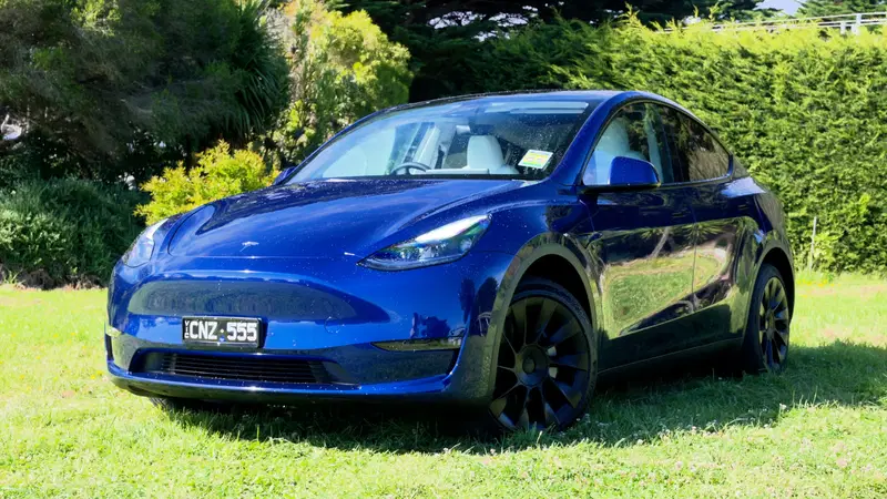 Blue Tesla Model Y parked outdoors in natural light on grass, showing a popular electric SUV known for strong resale value after 3 years